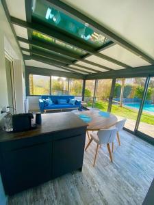 帕克斯港Magnifique maison avec piscine的厨房以及带桌椅的起居室。