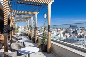 里斯本EPIC SANA Marquês Hotel的市景阳台配有桌椅。