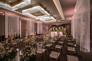 里斯本EPIC SANA Marquês Hotel的宴会厅配有桌椅和鲜花