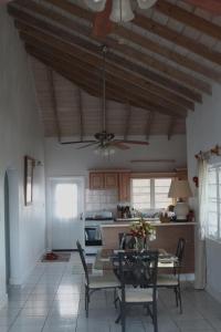 尼维斯Villa Benito的厨房配有桌椅和吊扇。