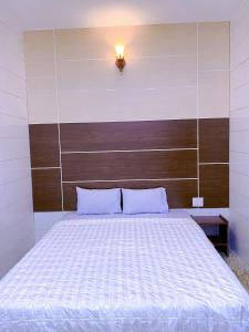 Thôn Tân HộiKhách sạn Ngọc Bích 2的一间卧室配有一张大床和木制床头板