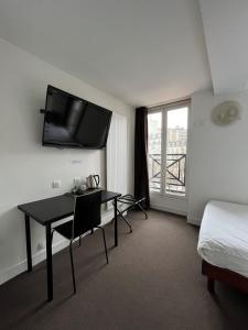 巴黎德拉图尔酒店 的酒店客房设有一张桌子和一台墙上的电视。