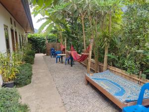 NongkhiawMeexok guesthouse的花园内带吊床和椅子的庭院