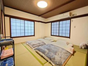 东京KIKI HOUSE的带两张床和两个窗户的房间