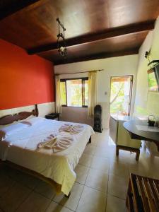 Núcleo MauáHotel Casa Alpina的一间卧室设有一张红色墙壁的大床