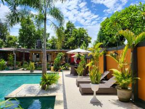 马塔兰Dewi Sri Guesthouse的一个带游泳池和棕榈树的度假村