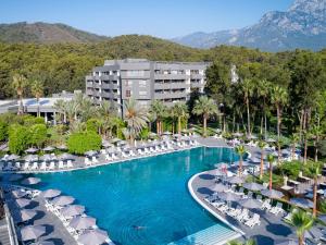 特基罗瓦Movenpick Resort Antalya Tekirova的度假村内带椅子和遮阳伞的游泳池