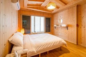 丽水市Elon Hanok Pension的一间带一张大床的卧室,位于带木墙的房间
