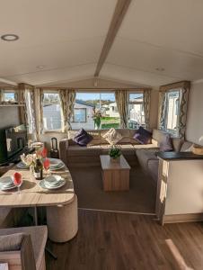 韦茅斯Sleeps 6 Modern and bright Caravan Littlesea Haven Weymouth的露营车的客厅,配有沙发和桌子
