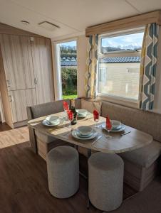 韦茅斯Sleeps 6 Modern and bright Caravan Littlesea Haven Weymouth的一间带桌椅的用餐室