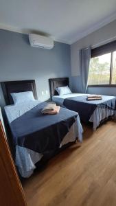 HohenauCasa de huéspedes Mariposa en manantial countryclub的一间卧室设有两张床和窗户。