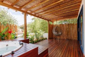 皮帕Pousada Alto da Pipa的木制甲板配有浴缸和吊床