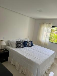 塞古罗港Ap Praia de Taperapuan Porto Seg的白色卧室配有一张带蓝色枕头的大床