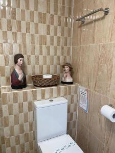 伊斯特布恩"The Italian" Seafront Apartment的一间带卫生间的浴室和墙上的两座雕像