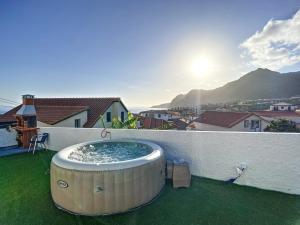 卡尼萨尔Casa da Avo by Atlantic Holiday的阳台一侧的热水浴池