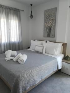 依诺罗达Aiolos Blu Luxury Apartments的一间卧室配有一张大床和毛巾