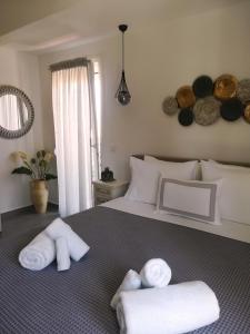 依诺罗达Aiolos Blu Luxury Apartments的一间卧室配有带毛巾的床