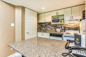 蓝山Condo 904 at North Creek Resort的厨房配有白色橱柜和花岗岩台面
