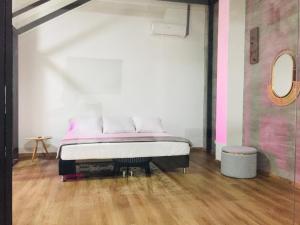 麦德林Soy Local Primavera的粉红色和白色墙壁间的一张床位