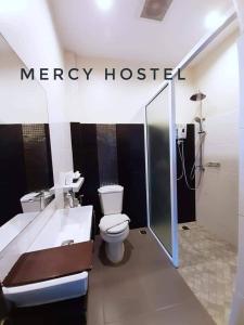 清莱Mercy Hostel的浴室配有白色卫生间和浴缸。