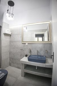 Káto LekhóniaCountryside luxury studios的浴室设有蓝色水槽和镜子