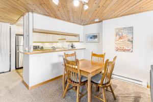 斯廷博特斯普林斯A Scent of Pine的厨房以及带木桌和椅子的用餐室。