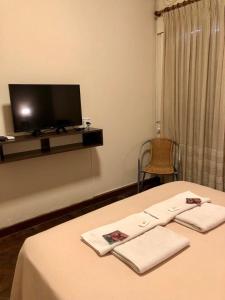 梅塞德斯镇Hotel Bonino的客房设有1张带电视的床和毛巾。