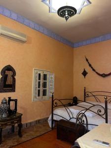 Nkob沙珍娜旅馆的一间卧室配有两张床和吊灯。