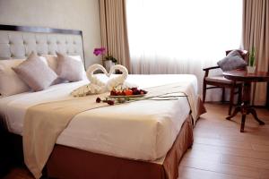 碧瑶Aura One Hotel的酒店客房,配有一张带两个天鹅的床