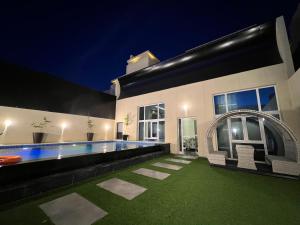 塔伊夫Arayik Resort的一座晚上设有游泳池的房子