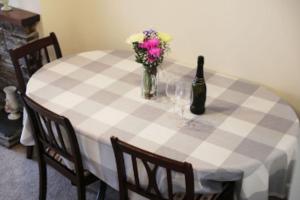 以撒港Waypast, Port Isaac Bay Holidays的一张带一瓶葡萄酒和鲜花的摆在桌边的桌子