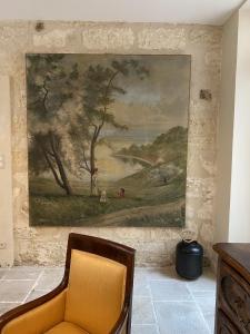 阿维尼翁N15 - Les Confidences - Chambres d'hôtes的挂在椅子旁边的墙上的画