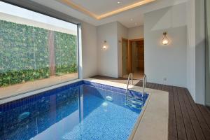 吉达Gladiolus Hotel的一座带大窗户的房屋内的游泳池