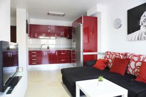 圭马尔港South Coast Apartment的客厅配有黑色沙发和红色橱柜