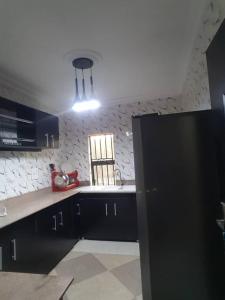 拉各斯3JD Lavishly Furnished 3-Bed Apartment的厨房配有黑色橱柜和红色用具