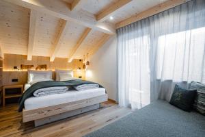 圣卡夏诺Bio Lüch Ruances的一间卧室设有一张带木制天花板的大床