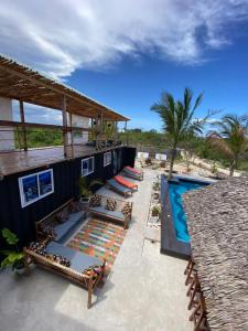 江比阿Jambiani Backpackers Hostel的一个带游泳池和带椅子的庭院的度假村