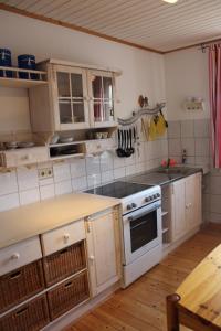 基希洪德姆Ferienwohnung an der Hundem的厨房配有白色橱柜和炉灶烤箱。
