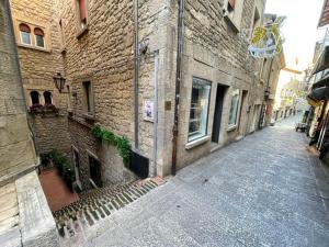 圣马力诺Locanda Jole Alloggio的砖楼旁一条小巷中的一条空街