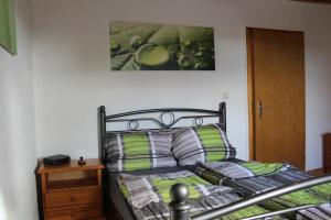 基希洪德姆Ferienwohnung an der Hundem的一间卧室配有一张带绿色和灰色枕头的床