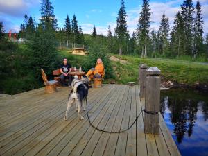 莫舍恩Blåfjell hundesenter fjellhotell的两人和一只狗站在木甲板上