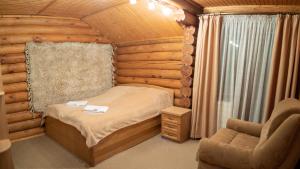 布克维Mini Hotel Laplandiya的小木屋内的卧室,配有一张床和椅子