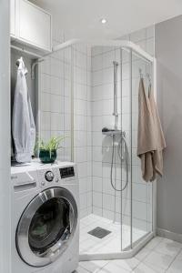 斯塔万格Koselig og sentralt midt i Fargegaten的带淋浴的浴室内的洗衣机