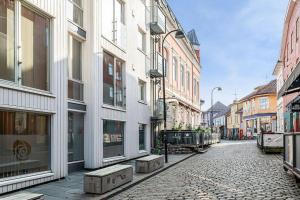 斯塔万格Koselig og sentralt midt i Fargegaten的城市中一条鹅卵石街道,有建筑