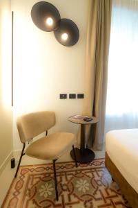 贝加莫Bergamo INN 21的一间卧室配有一张床、一把椅子和一张桌子