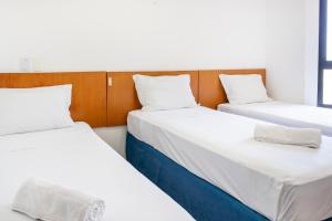 萨尔瓦多Praia a Vista Salvador Hotel的配有白色床单和枕头的三张床