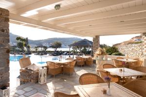 科里夏Porto Kea Suites的一个带桌椅的庭院和一个游泳池