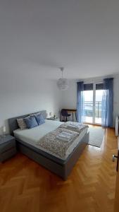 斯拉沃尼亚布罗德MED MAN Apartmani的一间卧室设有一张大床,铺有木地板