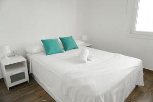 塔瓦伊瓦Alma del Mar的卧室内的白色床和蓝色枕头