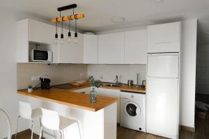 塔瓦伊瓦Alma del Mar的厨房配有白色橱柜、洗衣机和烘干机